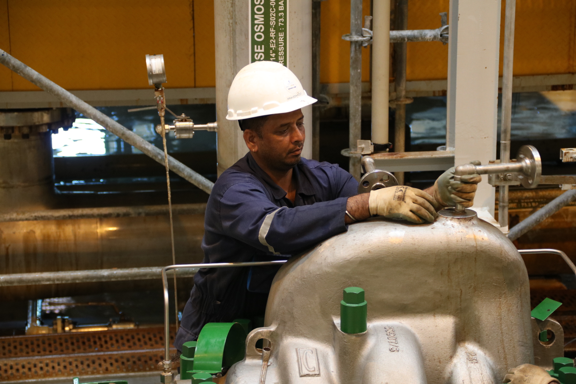 Technician inspecting high pressure SWRO pump